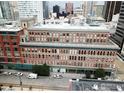 This aerial view shows the brick building's detailed architecture and surrounding city skyline at 1555 California St # 316, Denver, CO 80202