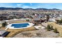 Aerial view of community pool, clubhouse, basketball court and play area in a new housing development with mountain views at 18740 W 85Th Dr, Arvada, CO 80007