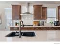 Modern kitchen featuring quartz countertops, dark wood cabinetry, stainless steel appliances, and a stylish backsplash at 18926 W 93Rd Ave, Arvada, CO 80007