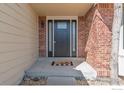 Inviting front entrance with a stylish black door, brick accents, and a welcoming 'hello' doormat at 1919 Breen Ln, Superior, CO 80027