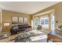 Sunlit living room featuring hardwood floors, a leather sofa, and large bay windows at 1919 Breen Ln, Superior, CO 80027