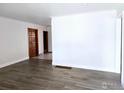 Spacious living room featuring wood floors, white walls, and wood trim door at 2085 Carr St, Lakewood, CO 80214