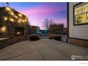 Cozy backyard patio with stone fireplace and stylish outdoor lighting, perfect for relaxing evenings at 2811 Twin Lakes Cir, Lafayette, CO 80026