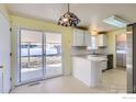 Functional kitchen featuring white cabinets, a stainless steel refrigerator, and a breakfast bar at 2907 University Ave, Longmont, CO 80503