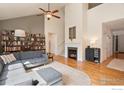 Bright living room with a cozy fireplace, tall vaulted ceilings, and hardwood floors at 2975 Thunder Lake Cir, Lafayette, CO 80026