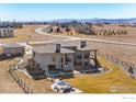 Rear exterior of the home showcasing outdoor seating areas and manicured landscaping at 3210 Mallard Creek Rd, Berthoud, CO 80513