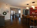 Open-concept dining room featuring hardwood floors, modern lighting, and access to kitchen and living spaces at 3310 Routt St, Wheat Ridge, CO 80033