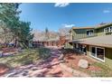 Spacious backyard featuring a stone pathway, lush greenery, and a deck, perfect for outdoor relaxation and entertaining at 4361 Butler Cir, Boulder, CO 80305