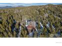 Aerial view of a cozy home surrounded by a lush green forest on a sunny day at 439 Ronnie Rd, Golden, CO 80403