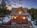 Inviting two-story wood cabin with a welcoming porch, set against a picturesque winter sky at 439 Ronnie Rd, Golden, CO 80403