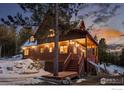 Wood home featuring a covered porch, garage, and ample space, set against a dusk sky at 439 Ronnie Rd, Golden, CO 80403