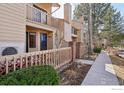 View of a townhouse with a private, enclosed patio and well-maintained landscaping at 5052 Buckingham Rd, Boulder, CO 80301