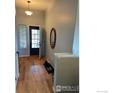 Bright entryway with wood floors, stylish mirror, and natural light streaming through the door at 781 Rodgers Cir, Platteville, CO 80651