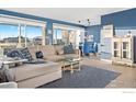 Inviting living room featuring a cozy sectional sofa, city views, and bright blue accent wall at 888 N Logan St # 11E, Denver, CO 80203