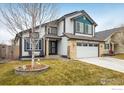 Two-story home with an attached two car garage, a tree and seating in the front lawn at 9094 W 103Rd Ave, Broomfield, CO 80021