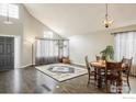 Inviting living room with dark hardwood floors, decorative rug, and large windows at 9094 W 103Rd Ave, Broomfield, CO 80021