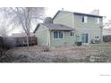 The backyard includes a green lawn, a wood fence, and mature trees at 9852 W 76Th Ave, Arvada, CO 80005