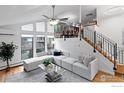 Bright, open living area features large windows, vaulted ceilings, a cozy sofa, and a modern staircase at 1425 Blue Sage Ct, Boulder, CO 80305