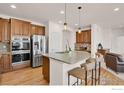 Modern kitchen with stainless steel appliances and a granite island with bar stool seating at 1429 Wandering Way, Castle Rock, CO 80109