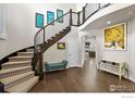 Elegant foyer showcasing a curved staircase, hardwood floors, and stylish decor at 1440 Eversole Dr, Broomfield, CO 80023