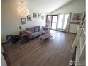 Inviting living room featuring hardwood floors, a modern sofa, and ample natural light from the windows at 1517 Atwood St, Longmont, CO 80501