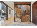 Foyer boasts stone walls, hardwood stairs, and a glimpse of the fireplace through the entry at 1652 Poplar Ave, Boulder, CO 80304