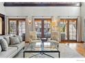 Bright living room with hardwood floors, multiple French doors, and a comfortable seating arrangement at 1652 Poplar Ave, Boulder, CO 80304