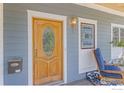 Ornate wood front door with stained glass window and rocking chair on covered porch at 1727 Mapleton Ave, Boulder, CO 80304