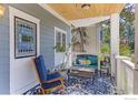 Inviting covered front porch features comfortable seating and a decorative stained-glass window at 1727 Mapleton Ave, Boulder, CO 80304