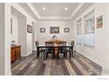 Elegant dining room with hardwood floors, tray ceiling, and ample natural light at 2232 Sedgwick Ct, Longmont, CO 80503