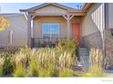 Charming front porch with seating, a red door, and well-maintained landscaping for a welcoming entrance at 22646 E Glidden Dr, Aurora, CO 80016