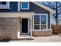 Inviting front entrance featuring a brick facade, contemporary door, and classic architectural details at 2285 Autumn Ridge Blvd, Lafayette, CO 80026