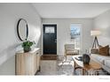 Welcoming entryway with a decorative front door, round mirror, and neutral furnishings at 229 S Cleveland Ave, Louisville, CO 80027