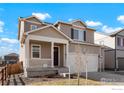 Inviting two-story home with a cozy front porch and well-maintained lawn at 2372 Mountain Sky Dr, Fort Lupton, CO 80621