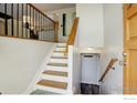 Bright entryway with wood-look stairs, modern railing, and easy access to different levels of the home at 2823 Mountain View Ave, Longmont, CO 80503