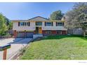 Inviting home with a well-kept lawn and a double garage, enhanced by lush landscaping and a clear driveway at 2823 Mountain View Ave, Longmont, CO 80503