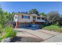 Spacious home features a two-car garage and an expansive driveway, complemented by mature trees and green lawn at 2823 Mountain View Ave, Longmont, CO 80503