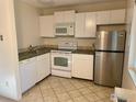 Functional kitchen featuring white appliances, tile flooring, and compact layout at 3161 Madison Ave # 310, Boulder, CO 80303