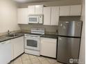 Cozy kitchen with tile flooring, stainless steel refrigerator, and practical appliances at 3161 Madison Ave # 310, Boulder, CO 80303