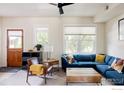 Living room showcasing a blue sectional couch and natural light from large windows at 3210 Iron Forge Pl # 103, Boulder, CO 80301