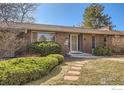 Well-maintained brick home showcasing mature landscaping and a stone walkway at 325 Fox Ct, Boulder, CO 80303