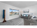 Light-filled living room featuring comfortable seating and an expansive window at 326 Berwick Ave, Firestone, CO 80520