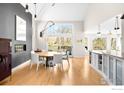 Dining room featuring a table, fireplace, views of the backyard, and an open-concept kitchen with island at 379 W Arapahoe Ln, Boulder, CO 80302