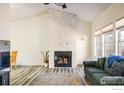 Bright living room with vaulted ceilings, fireplace, and large windows providing ample natural light at 3823 Paseo Del Prado, Boulder, CO 80301