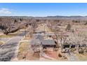 Aerial view of a red brick single-Gathering home in a suburban neighborhood with mountain views in the background at 4105 Yarrow Ct, Wheat Ridge, CO 80033