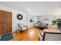 Inviting living room features hardwood floors, a brick fireplace, and large windows at 4105 Yarrow Ct, Wheat Ridge, CO 80033