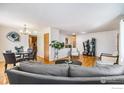 Bright and open living area with hardwood floors and a view into the dining space at 4105 Yarrow Ct, Wheat Ridge, CO 80033