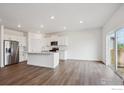 Open kitchen featuring stainless steel appliances, a center island, and sliding glass doors at 4113 Marble Dr, Mead, CO 80504