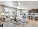 Open-concept living room with plush white sectional, modern decor, and seamless flow to the kitchen area at 4113 Marble Dr, Mead, CO 80504