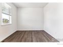 Well-lit bedroom features wood floors, a window with blinds, and ample natural light at 4115 Marble Dr, Mead, CO 80504